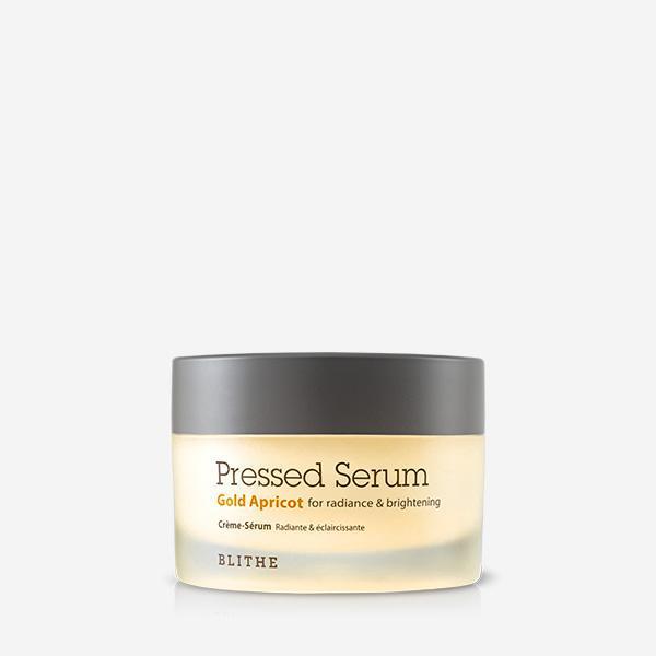 Blithe Pressed Serum Gold Apricot 50ml — gold-tinted jar with lid beside it on warm background